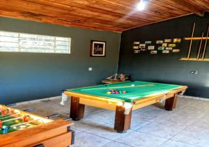 a ping pong table in a room with a pool at Casa de Temporada em Capitólio (Paz e Tranquilidade) in Capitólio