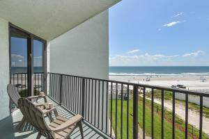 a balcony with two chairs and a view of the beach at Ocean Trillium Suites in New Smyrna Beach