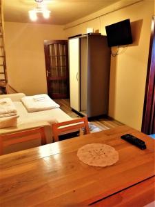 ミエルクレア・チュクにあるOxigen Lux Apartmentのベッド2台、テーブル、冷蔵庫が備わる客室です。