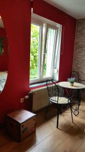 マルシュ・アン・ファメンヌにあるB&B Au Jardin Fleuriのテーブルと椅子、窓が備わる客室です。