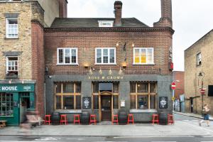 倫敦的住宿－PubLove @ The Rose & Crown，前面有红凳的砖砌建筑