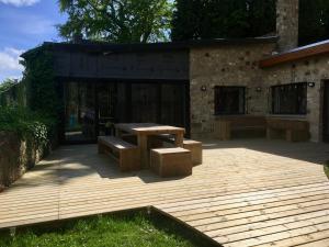 a picnic table and benches on a wooden deck at Châtelet de Barbençon in Barbençon