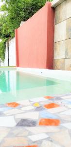 a swimming pool with glass floors and a red wall at Casa con alberca climatizada privada para 8 personas in Emiliano Zapata