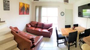 a living room with a couch and a table at Casa con alberca climatizada privada para 8 personas in Emiliano Zapata