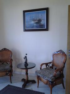 a room with two chairs and a table and a picture at Guest House Golden Flake 4km from Bolata beach in Bŭlgarevo