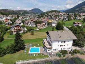 an aerial view of a village with a house and a pool at Hotel Due Pini in Baselga di Pinè
