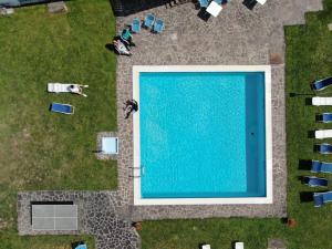 an overhead view of a swimming pool with people and chairs at Hotel Due Pini in Baselga di Pinè