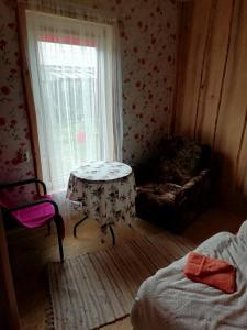 a room with a table and a chair and a window at Brīvdienu māja ar kopējo virtuvi in Salacgrīva