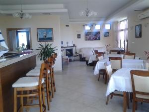 a restaurant with white tables and chairs and a fireplace at Guest House Golden Flake 4km from Bolata beach in Bŭlgarevo
