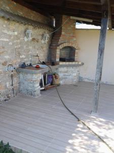 an outdoor kitchen with a stone counter with a fireplace at Guest House Golden Flake 4km from Bolata beach in Bŭlgarevo