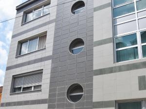 a building with round windows on the side of it at Lux Apartment I Prijedor in Prijedor