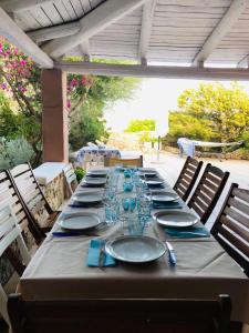 a long table with plates and wine glasses on it at Villa Grace in La Maddalena