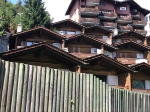 einem Holzzaun vor einem Gebäude in der Unterkunft Appartamento chalet in Laax