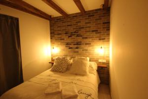 ein Schlafzimmer mit einem Bett mit Ziegelwand in der Unterkunft La Rosa de los Vientos in Casas del Abad