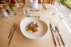 a white plate of food on a table with silverware at Biohotel Mattlihüs in Bad Hindelang
