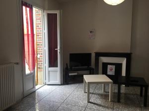 salon z kominkiem i stołem w obiekcie La petite maison de Lilou w mieście Romilly-sur-Seine