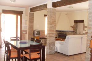 cocina y sala de estar con mesa y sillas en Villa Almendros - Deniasol, en Denia