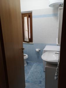 a bathroom with a toilet and a sink at Hawaii Siciliane in Castelluzzo