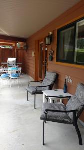 a patio with two chairs and a table and a tv at Nestledown B&B in Halfmoon Bay