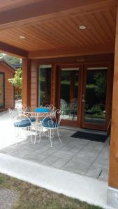 un patio con mesa y sillas frente a una casa en Nestledown B&B en Halfmoon Bay