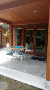 une terrasse avec une table et des chaises devant une maison dans l'établissement Nestledown B&B, à Halfmoon Bay