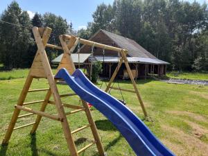 a swing set with a blue slide and a ladder at Huntingbox in Purila