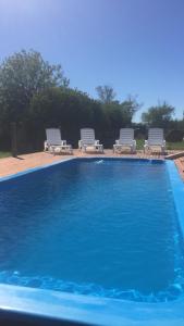 una gran piscina con 2 sillas en Casa Mansa Puro Campo en Lobos