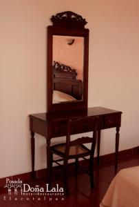 a wooden desk with a mirror and a chair at Hotel Posada Doña Lala in Tlacotalpan