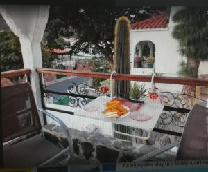 una mesa con comida en un balcón con cactus en Casa El Pino, en Mogán