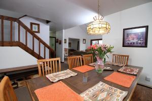 a dining room with a table with a vase of flowers at Three bedroom with Beautiful View & Short Walk to the Home Stretch Trail! Frosty in Killington
