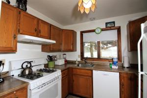 a kitchen with wooden cabinets and a white stove top oven at Three bedroom with Beautiful View & Short Walk to the Home Stretch Trail! Frosty in Killington
