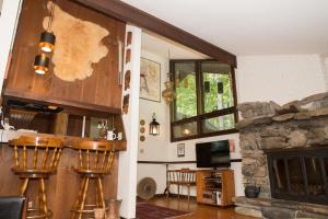 a living room with a stone fireplace and wooden stools at Perfect secluded 3 bedroom cozy getaway home Hawk Landing in Pittsfield