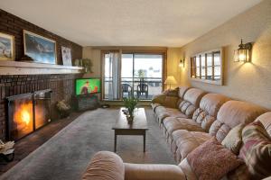a living room with a large couch and a television at Ski on ski off, conveniently located, 2 bedroom condo with beautiful views, access to indoor pool Sunrise B3 in Killington