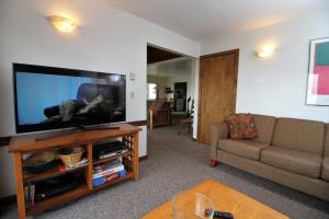 a living room with a flat screen tv and a couch at Three bedroom with Beautiful View & Short Walk to the Home Stretch Trail! Frosty in Killington