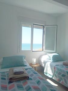 Un dormitorio con dos camas y dos ventanas. en Beach front line luxury apartment, 2 bedroom, en El Campello 19 fotos más