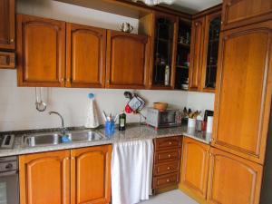 een keuken met houten kasten en een wastafel bij Iknos House in Monserrato