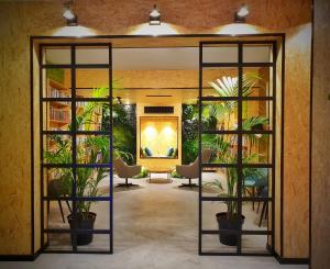 a lobby with potted plants and a painting on the wall at MB Hostels Premium ECO - Adults Recommended in Nerja