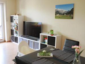 un salon avec une table et une télévision dans l'établissement Ferienwohnung - Missen-Wilhams Allgäu, à Missen-Wilhams
