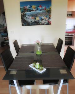 una mesa de comedor negra con sillas y una pintura en Ferienwohnung - Missen-Wilhams Allgäu, en Missen-Wilhams