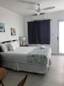 1 dormitorio con 1 cama y ventilador de techo en Amapola Beachfront Studio, en San Juan