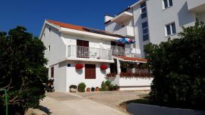 a white apartment building with flowers on the balconies at Apartments Magdalena in Pag