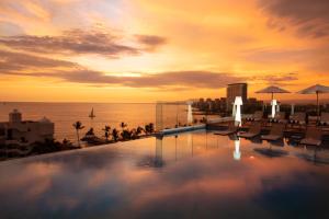 a swimming pool on top of a building with the ocean at Crown Paradise Golden All Inclusive Resort - Adults Only in Puerto Vallarta