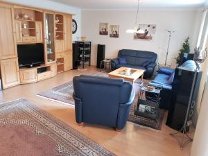 een woonkamer met twee blauwe stoelen en een televisie bij Ferienhaus am Rheintor in Andernach