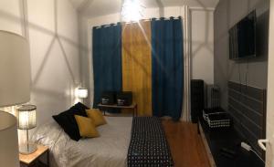- une chambre avec un lit doté d'un rideau bleu dans l'établissement Jules Janin, à Saint-Étienne