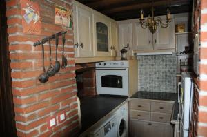 a kitchen with a brick wall and white appliances at Gîte Mi Do in Tourly