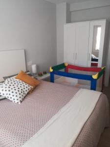 1 dormitorio con 1 cama y 1 silla colorida en Apartamento tranquilo y luminoso, en Mundaka