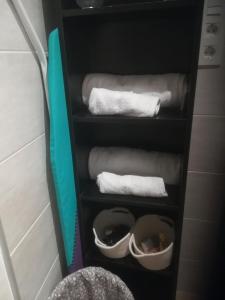 a towel rack with towels and shoes in a bathroom at Apartamento tranquilo y luminoso in Mundaka
