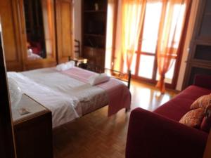 1 dormitorio con 1 cama y 1 sofá en B&B Colombo, en Pisa