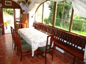 Villa Blanka في Horní Podkozí: غرفة طعام مع طاولة وكراسي ونوافذ