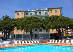 a hotel with a swimming pool with chairs and trees at Hotel Mayola Mhotelsgroup in San Bartolomeo al Mare